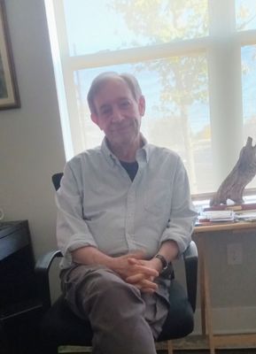 A man sitting in a chair in front of a window