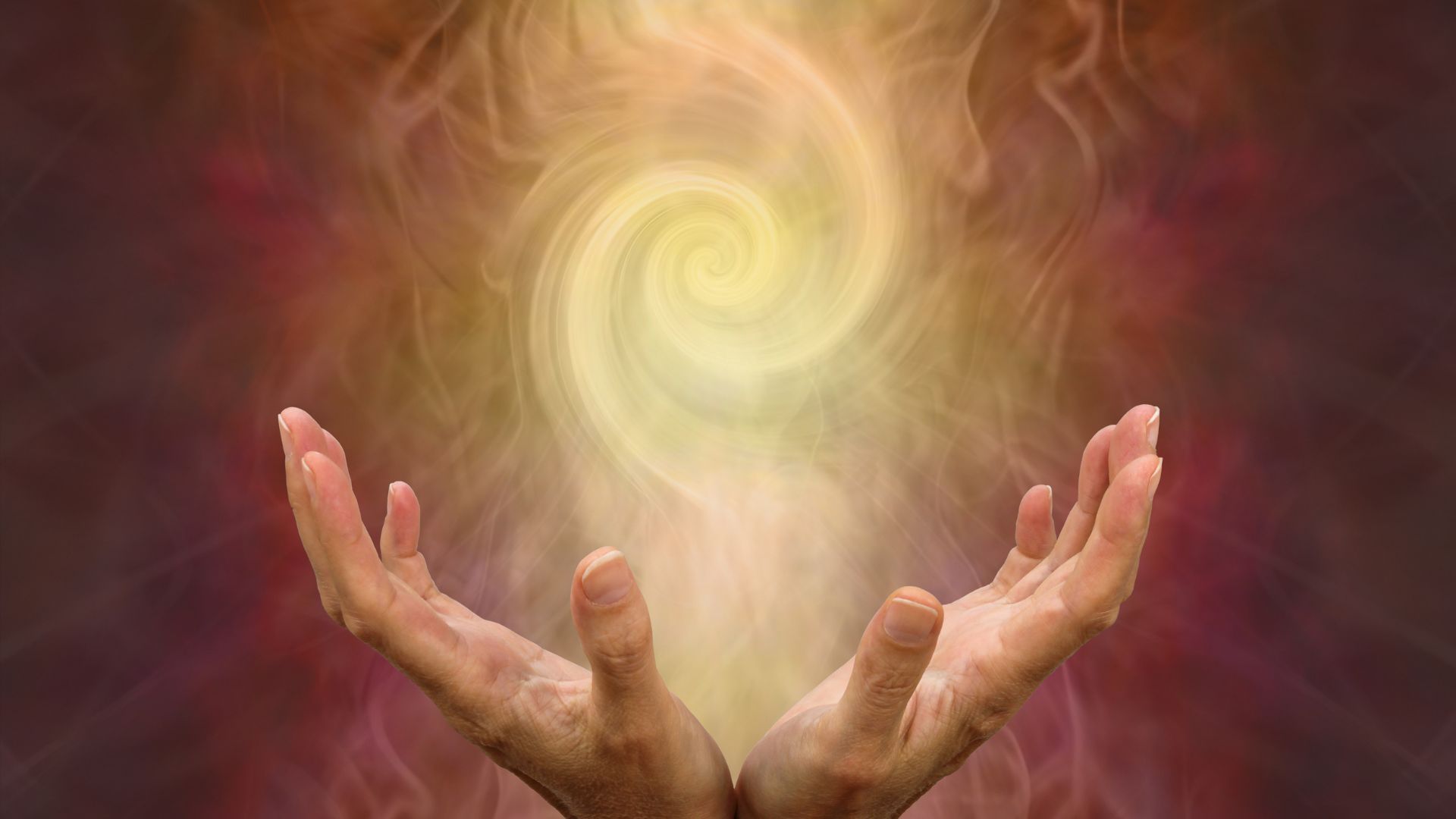 A person holding their hands in front of a colorful background