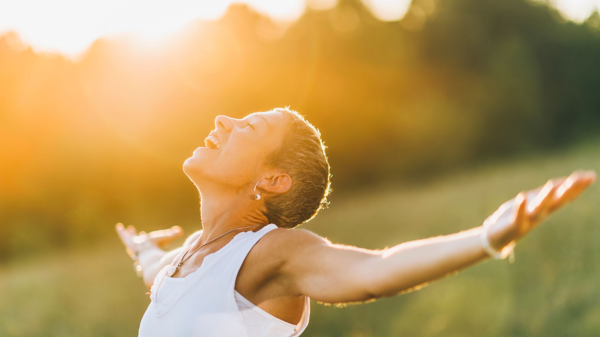 A woman standing in a field with her arms outstretched